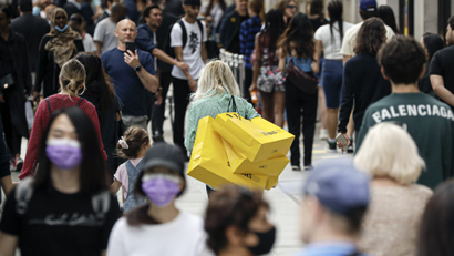 People walk with bags after shopping at the Selfridges department store in London
