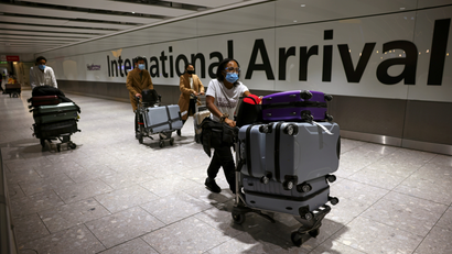 Travellers walk through the arrivals area at Heathrow