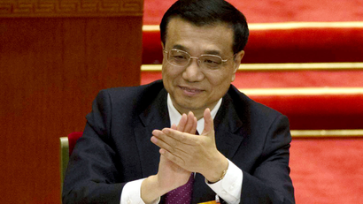 Chinese premier-in-waiting, Li Keqiang applauds after a speech by Wu Bangguo, outgoing Chairman of the National People's Congress, unseen, during a plenary session of the NPC held in Beijing's Great Hall of the People Friday, March 8, 2013. Wu praised the body Friday for upholding the ruling Communist Party's leading role and for rejecting Western models of multiparty democracy. Wu's statements came in his final address to the NPC during its annual session, at which Wu and other top leaders will step down following a decade in power.