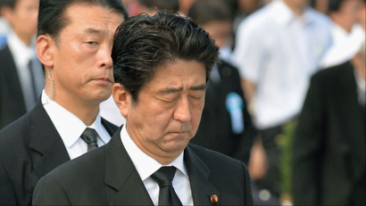 Japan's Prime Minister Shinzo Abe (C) offers silent prayers for victims of the 1945 atomic bombing, in the Peace Memorial Park in Hiroshima August 6, 2013, on the 68th anniversary of the world's first atomic bombing on the city. Mandatory Credit. REUTERS/Kyodo