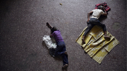 Men sleep on the bus station floor in India