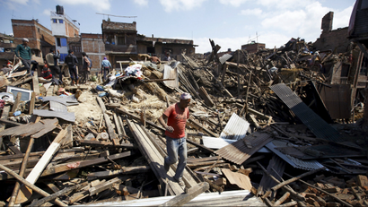 A man walks on the rubble of collapsed houses following Saturday's earthquake in Bhaktapur, Nepal April 27, 2015.