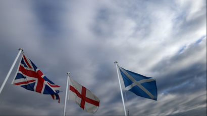 From left, the Union Jack, St George's Cross and the Saltire fly at Adderstone, England, Monday, Sept. 8, 2014. The British government plans to offer Scotland more financial autonomy in the coming days as polls predict a very close vote in the September 18 on Scottish independence. (AP Photo/Scott Heppell)