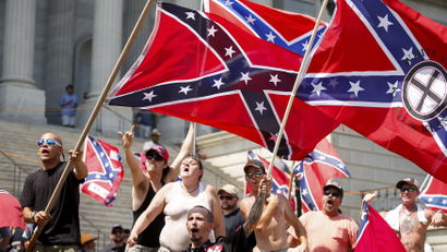 Members of the Ku Klux Klan yell as they fly Confederate flags during a rally at the statehouse in Columbia, South Carolina July 18, 2015. A Ku Klux Klan chapter and an African-American group planned overlapping demonstrations on Saturday outside the South Carolina State House, where state officials removed the Confederate battle flag last week.