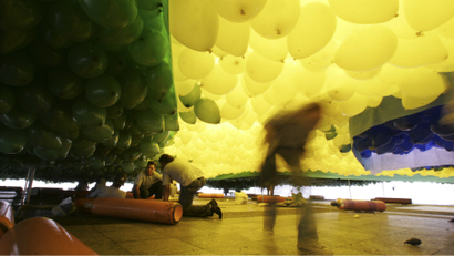 Men arrange balloons, in the colors of Brazil's national flag, before releasing them into the air during a year-end ceremony in downtown Sao Paulo.