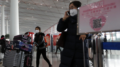 People wearing masks for protection against air pollution push their luggage at the Beijing Capital International Airport as the capital of China is shrouded by heavy smog on Wednesday, Dec. 21, 2016. Beijing and much of industrial northern China are in the midst of a "red alert," the highest level in China's four-tiered pollution warning system. The alert has affected 460 million people, according to Greenpeace East Asia, which calculated that about 200 million people were living in areas that had experienced levels of air pollution more than 10 times above the guideline set by the World Health Organization. (AP Photo/Andy Wong)