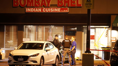 Police officers stand in front of Bombay Bhel restaurant, where two men set off a bomb, in Mississauga, Ontario