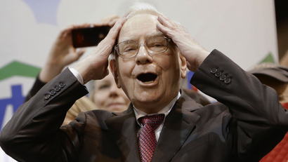 Berkshire Hathaway Chairman and CEO Warren Buffett reacts at the newspaper throwing competition while touring the exhibition floor prior to the annual shareholders meeting on Saturday, May 3, 2014, in Omaha, Neb. More than 30,000 shareholders are expected to fill the CenturyLink Arena to hear Buffett and Berkshire Vice Chairman Charlie Munger discuss their business. (AP Photo/Nati Harnik)
