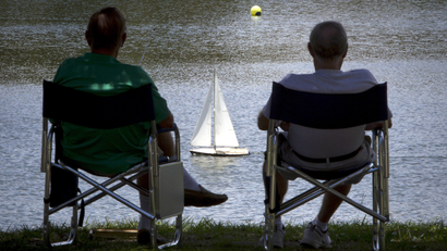 Men sail model boats at a pond in Spanish Springs at the world's largest retirement community