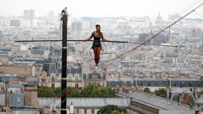 Tightrope walker Tatiana-Mosio Bongonga advances on a tightrope as she scales the Monmartre hill towards the Sacre Coeur Basilica (not pictured) in Paris, France, July 20, 2018.