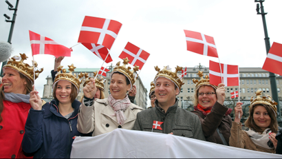 Fans of the Danish royal family carry Danish flags as they await the arrival of Danish Crown Prince and Princess