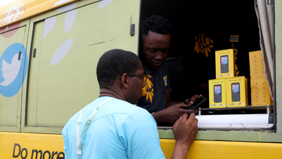 An MTN service rep attends to a customer through the window of a bus