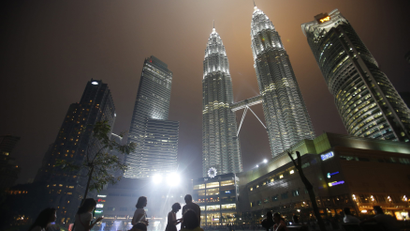 Tourists gather near the foot of the haze-covered landmark Petronas Twin Towers in Kuala Lumpur