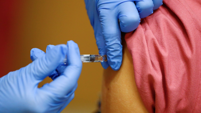 A member of the medical staff receives a flu vaccine at the department where patients suffering from the coronavirus disease (COVID-19) are treated in the Intensive Care Unit (ICU) at Havelhoehe community hospital in Berlin, Germany, October 30, 2020.
