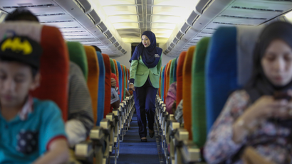 A Rayani Air flight attendant walks down the aisle on board before departure at Kuala Lumpur International Airport
