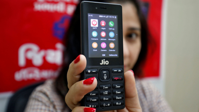 A sales person displays JioPhone as she poses for a photograph at a store of Reliance Industries' Jio telecoms unit, on the outskirts of Ahmedabad