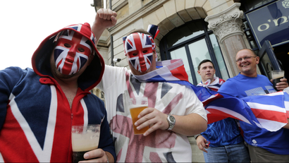 British supporters drink beer outside a pub prior to the start of the men's group A soccer match between Britain and Uruguay, at the Millennium Stadium in Cardiff, Wales, at the 2012 London Summer Olympics, Wednesday, Aug. 1, 2012. (AP Photo/Luca Bruno