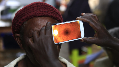 A woman undergoes an eye examination using a smartphone.