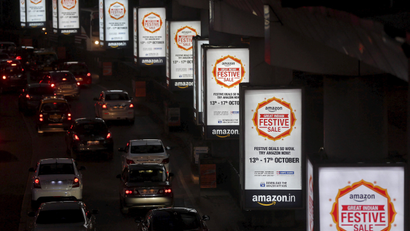 Traffic moves on a road past advertisements of Indian online marketplace Amazon, in Mumbai, India