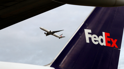A plane takes off behind the tail of a FedEx plane at the company's hub north of Paris in this 2016 file photo.