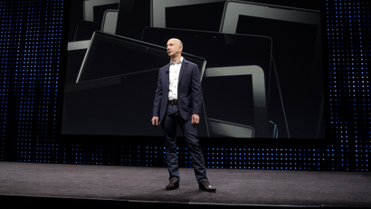 Amazon CEO Jeff Bezos stands with Kindle Fire tablets in the background