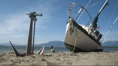 A stranded sailboat's anchor sits in the sand of Kitsilano Beach in Vancouver, British Columbia.
