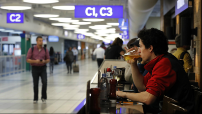 Man drinking a pint in an airport