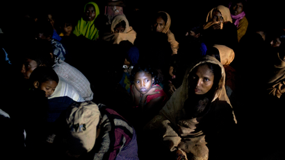 Light from a torch falls on the face of a Rohingya Muslim girl sitting with a group on a raft made with plastic containers on which they crossed over from Myanmar into Bangladesh, as they wait for the permission to proceed forward, near Shah Porir Dwip, Bangladesh, Friday, Nov. 10, 2017. U.N. Secretary-General Antonio Guterres said Friday it is "an absolutely essential priority" to stop all violence against Myanmar's Rohingya Muslims, allow them to return to their homes, and grant them legal status.