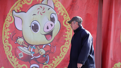 A man walks past a poster celebrating the upcoming Lunar New Year of the Pig at Ditan Park in Beijing, China January 28, 2019.