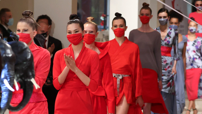 Models wear face masks as they present creations of the 2021 summer collection by designer Anja Gockel
