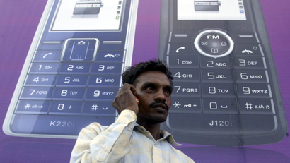 A man speaks on a mobile phone in front of a billboard in Chandigarh