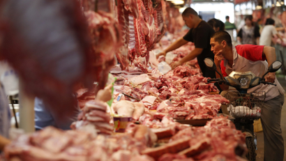 A customer chooses meat at a meat market in Beijing May 31, 2013. With more money in their pockets, millions of Chinese are seeking a richer diet and switching to beef, driving imports to record levels and sending local meat firms abroad to scout for potential acquisition targets among beef farmers and processors. Picture taken May 31, 2013. REUTERS/Kim Kyung-Hoon (CHINA - Tags: FOOD BUSINESS) - RTX10D4M