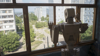 A robot looks out a window longingly.