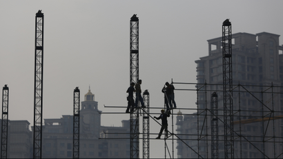 Workers install scaffolding at a construction site in front of residential buildings during a hazy day in Shanghai November 6, 2013. REUTERS/Aly Song