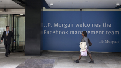People walk near a sign welcoming the IPO of Facebook outside the offices of J.P. Morgan in New York City, New York, May 4, 2012. Facebook Inc aims to raise about $10.6 billion in Silicon Valley's largest IPO, dwarfing the coming-out parties of tech companies like Google Inc and granting the world's largest social network a market value close to Amazon.com's. REUTERS/Lee Celano