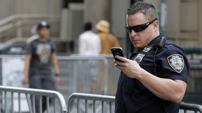 A New York City Police Department (NYPD) officer uses his iPhone while on duty in New York