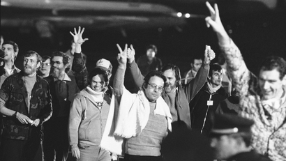 Iran hostages, A group of unidentified American hostages give the victory sign as they emerge from an Algerian aircraft in Algiers after their flight from Teheran where they had been held captive for 444 days in Iran, Jan. 21, 1981.