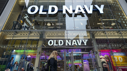 A pedestrian walks past a colorful Old Navy store in Times Square