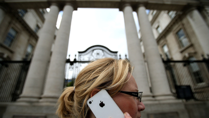 A woman on her Apple iPhone outside Government Buildings in Dublin today as Taoiseach Enda Kenny reiterated that Ireland does not negotiate specific tax deals with individual companies amid mounting criticism of Apple's corporate tax arrangements and its relationship with Ireland.