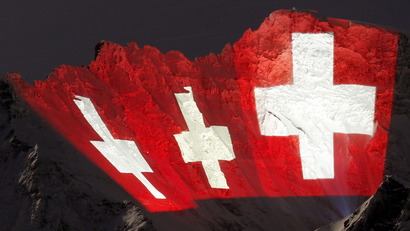 A giant light installation of the flag of Switzerland, by Swiss artist Gerry Hofstetter, illuminates the north face of the Jungfrau in the Bernese Oberland January 12, 2012. The installation commemorates the 100-year anniversary of the Jungfrau railway, which first began operations in the year 1912. The light left of the installation is Europe's highest railway station, the Jungfraujoch station, at an altitude of 3,454 metres (11,332 ft). REUTERS/Arnd Wiegmann (SWITZERLAND - Tags: TRAVEL SOCIETY ANNIVERSARY)