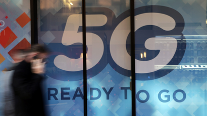 A man walks past a 5G sign in Monaco