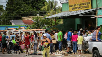 People take food from a looted shop in Venezuela