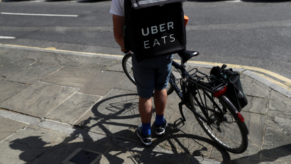 A cyclist prepares to delivery an Uber Eats food order in London.