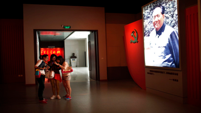 Teens play with their smartphones at a museum in China.