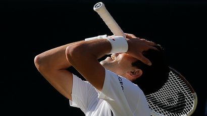 Novak Djokovic of Serbia puts his head in his hands after losing a point during the men's singles final against Roger Federer of Switzerland at the All England Lawn Tennis Championships in Wimbledon, London, Sunday, July 6, 2014. (AP Photo/Pavel Golovkin)