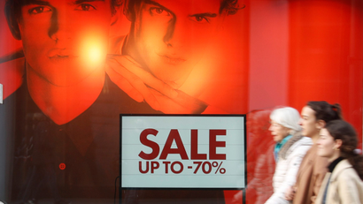 A sale is advertised in a fashion store's window display