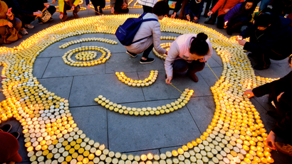 People place candles in the shape of a monkey face to pray for good luck at Guangren Temple in China.