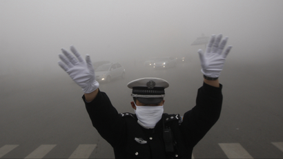 A traffic policeman signals to drivers during a smoggy day in Harbin, Heilongjiang province, October 21, 2013. The second day of heavy smog with a PM 2.5 index has forced the closure of schools and highways, exceeding 500 micrograms per cubic meter on Monday morning in downtown Harbin, according to Xinhua News Agency. REUTERS/China Daily