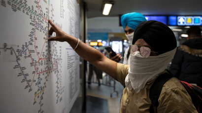 Commuters wearing handkerchiefs as masks look at a metro train map at a station, amid coronavirus disease (COVID-19) fears, in New Delhi, India, March 13, 2020. REUTERS/Danish Siddiqui
