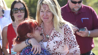 Parents wait for news after a reports of a school shooting in parkland, fla.